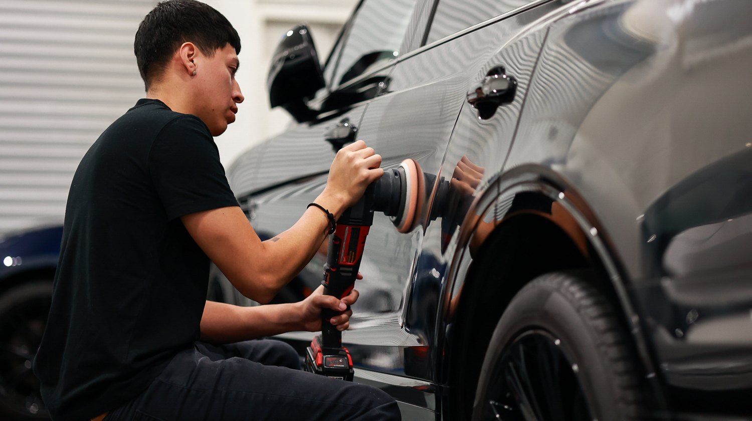 Polishing the front door of a black Bentley Bentayga Speed in sections