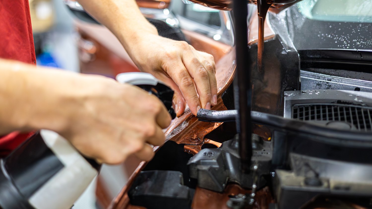 Spraying slip solution at the fender edge of a copper Lexus RX 350