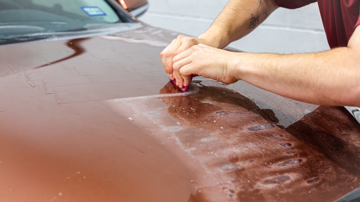 Squeegeeing paint protection film on the hood of a copper Lexus RX 350