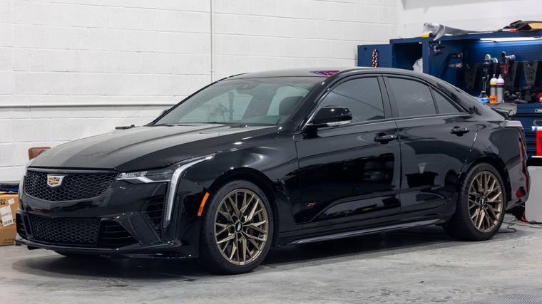 Black Cadillac CT4-V Blackwing paint protection film, paint correction — front three quarter in shop at Humble Crew Auto Spa, Plano TX