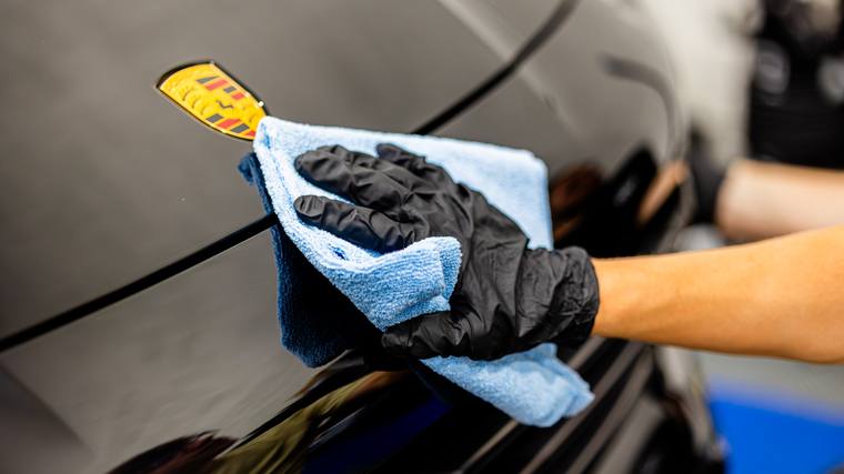 Black Porsche Cayenne ceramic coating, paint correction — wiping hood crest at Humble Crew Auto Spa, Plano TX
