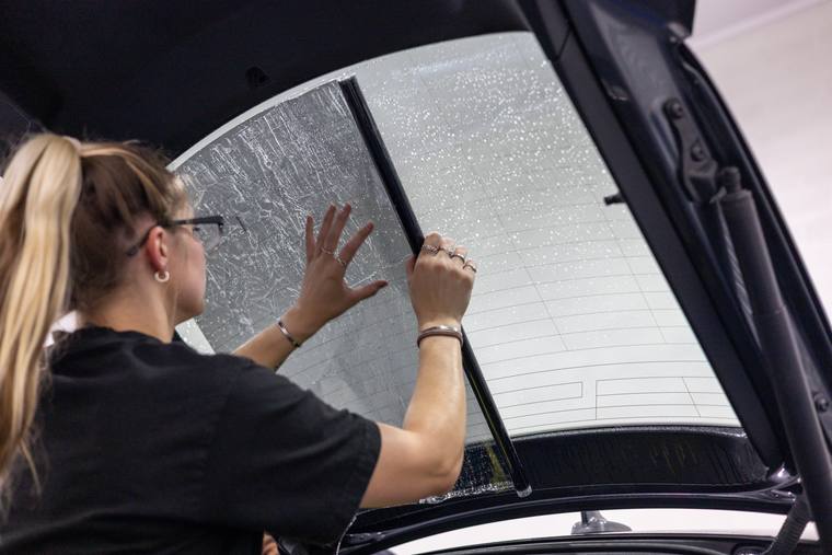 Gray Tesla Model Y window tint — positioning rear window tint at Humble Crew Auto Spa, Plano TX