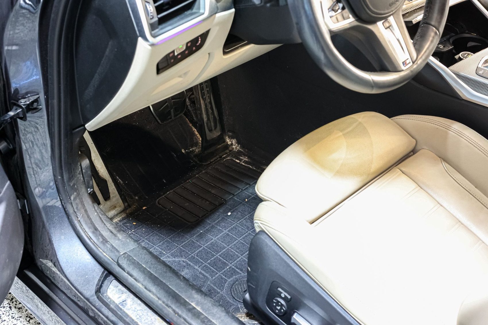 A BMW driver's seat and floor before detailing