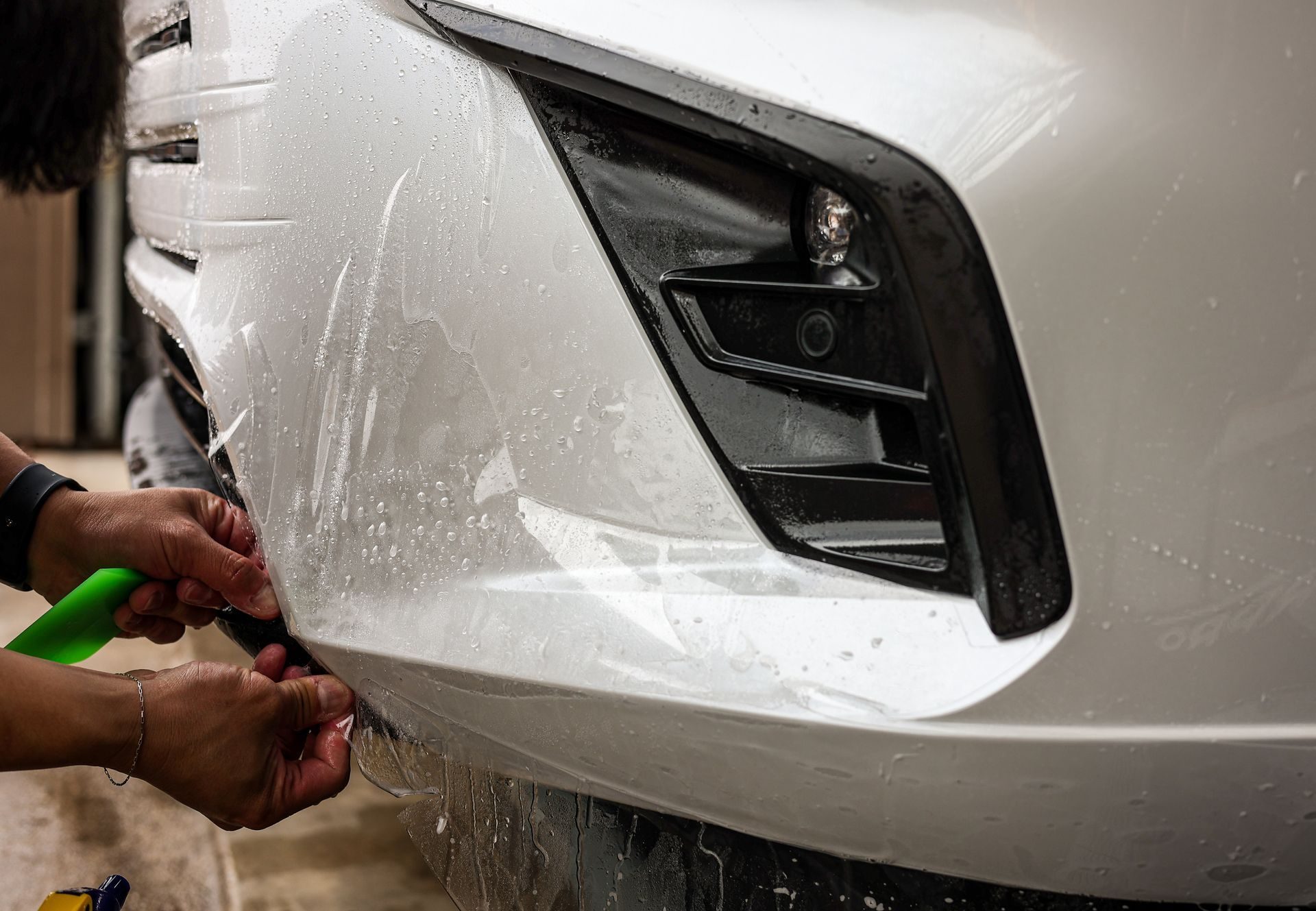 Paint protection film going onto a bumper